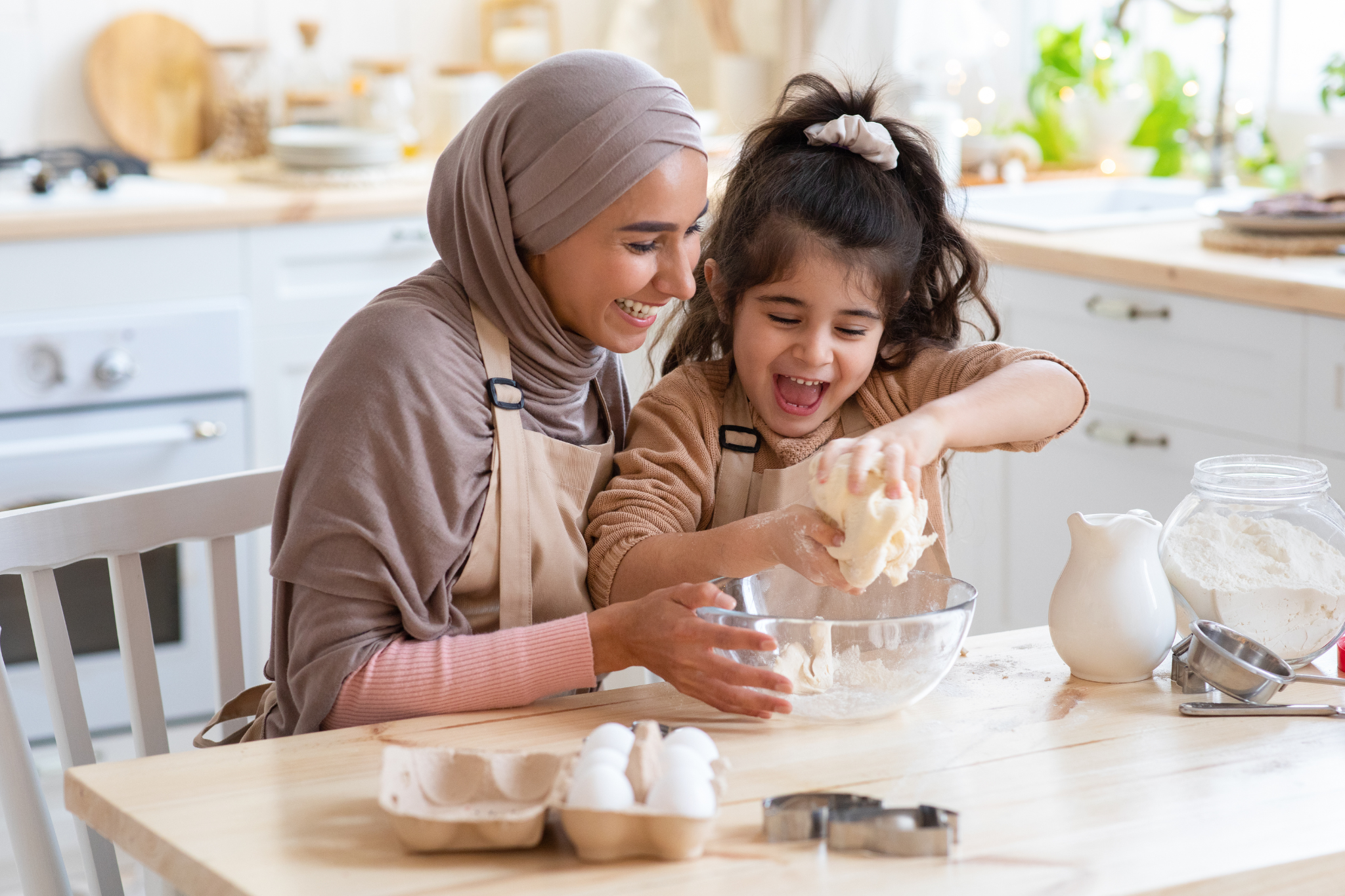 Thyroid Health Image Alt Text; Young mother and daughter baking in the kitchen