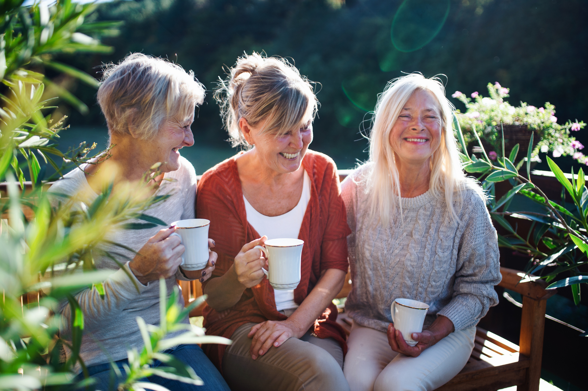 Pituitary & Adrenal Health Image Alt Text: three older woman drinking tea in the garden