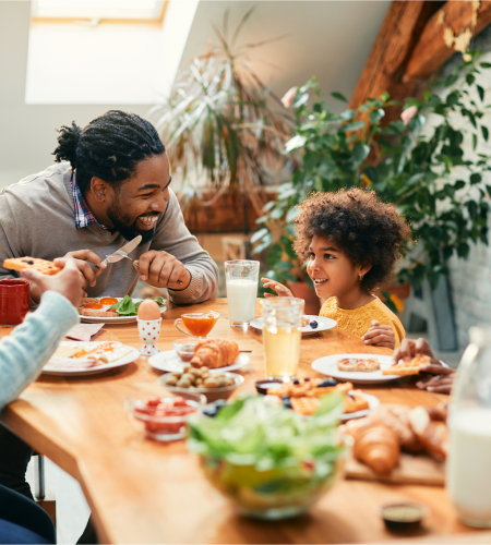 Muscle & Joint Health Img Alt Text; Young Family enjoying dinner at home at dinner table