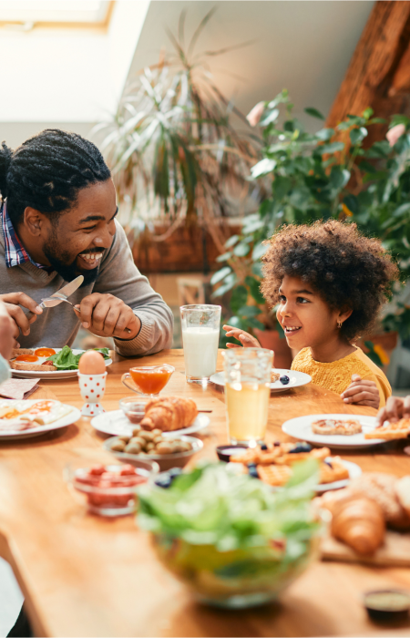 Muscle & Joint Health Img Alt Text; Young Family enjoying dinner at home at dinner table