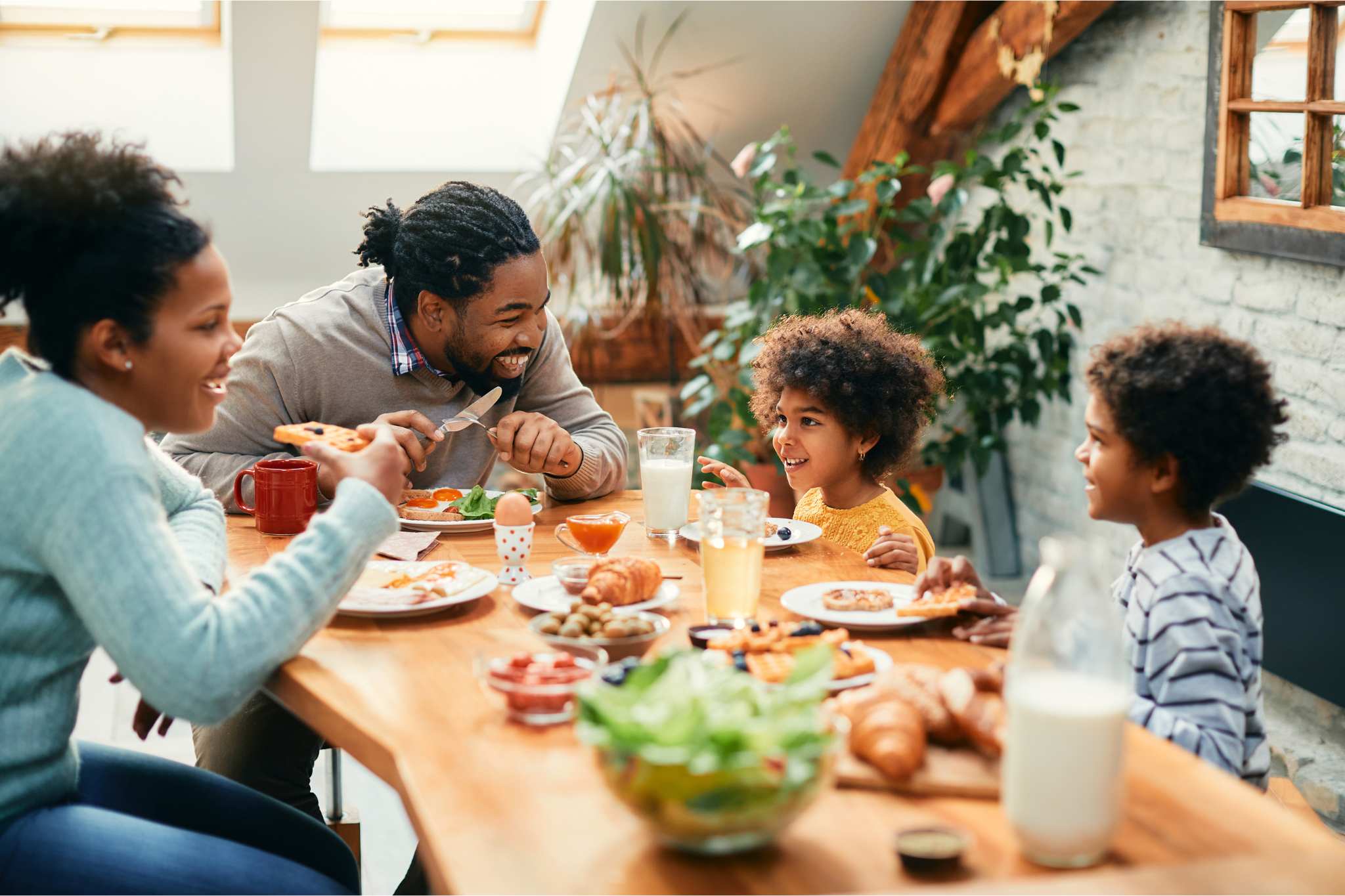 Muscle & Joint Health Img Alt Text; Young Family enjoying dinner at home at dinner table
